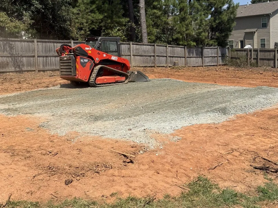 Track loader spreading crusher run gravel for a pad behind a home, gravel driveways